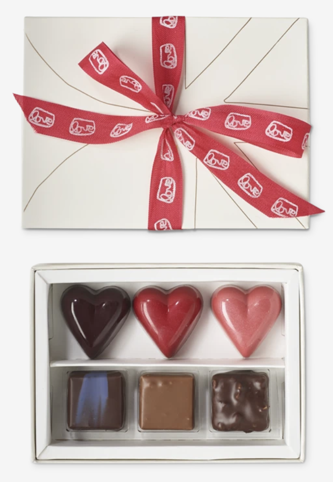 Box of three heart-shaped chocolates and three bonbons, with a ribbon around the box lid