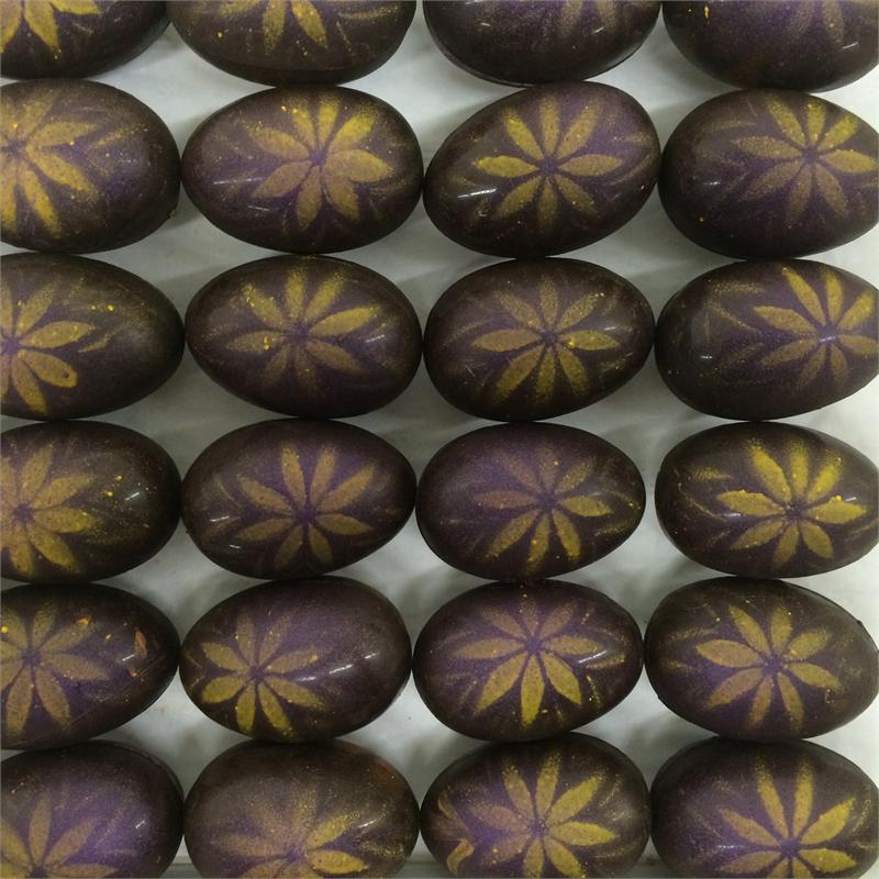 rows of chocolate eggs decorated with violet and lemon flowers